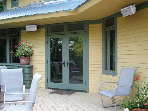 Weatherproof speakers mounted under patio eaves